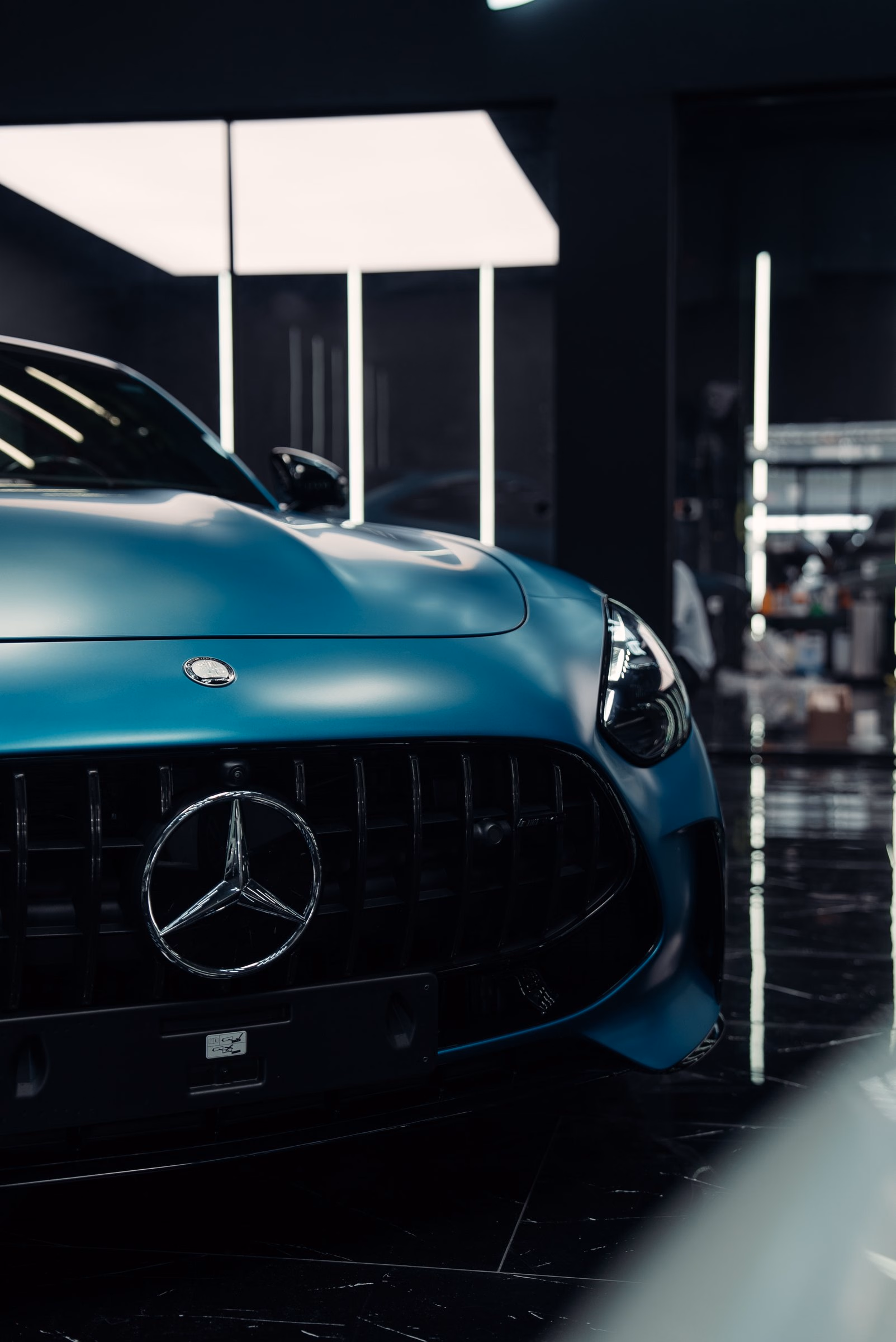 A satin teal Mercedes-AMG GT photographed from a low front angle after full body paint protection film