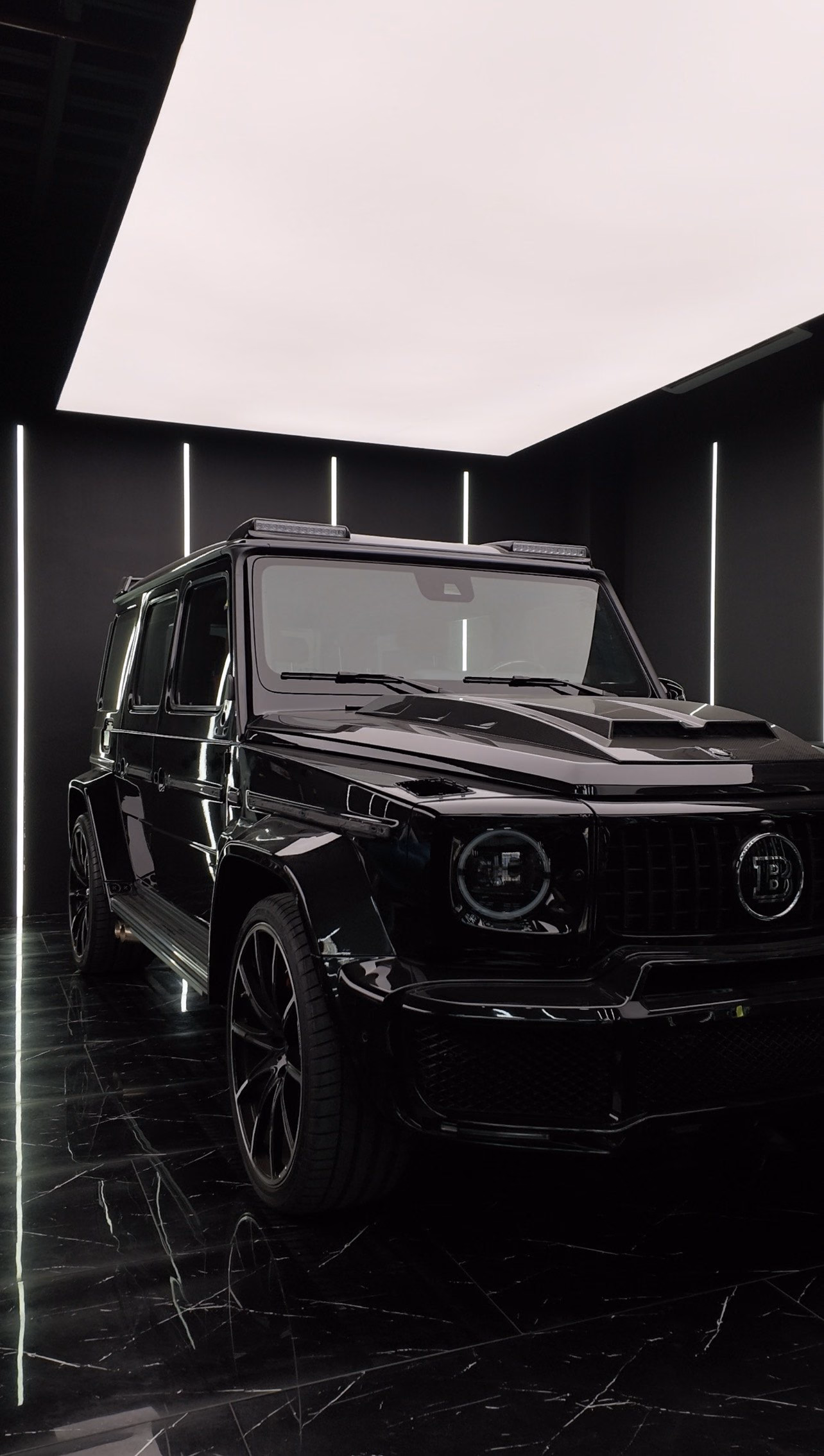 A gloss black Brabus G63 photographed from the front three-quarter after window tinting