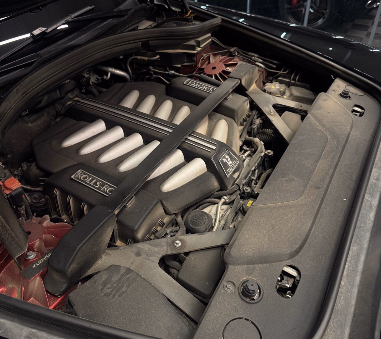 The V12 engine bay of a Rolls-Royce before cleaning, with dust settled across every surface
